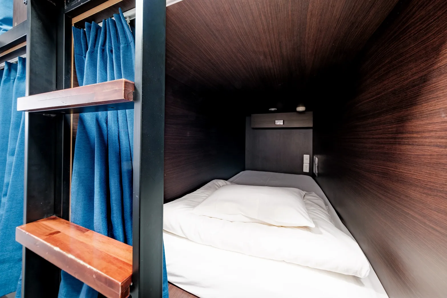 Capsule bed interior with open curtain at Hostel JAZ Ueno Tokyo