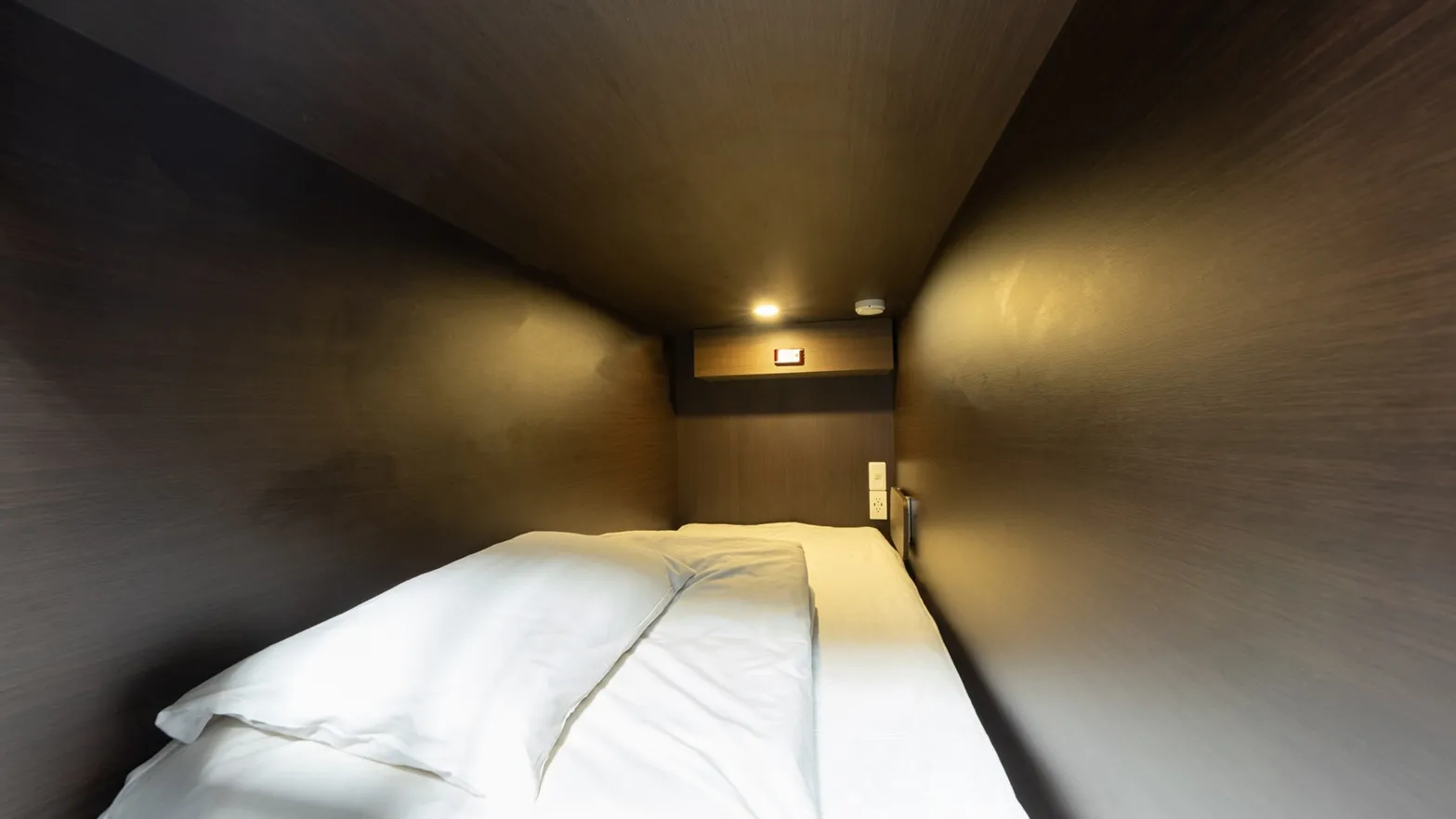 Spacious capsule bed interior with private lighting and power outlet at Hostel JAZ
