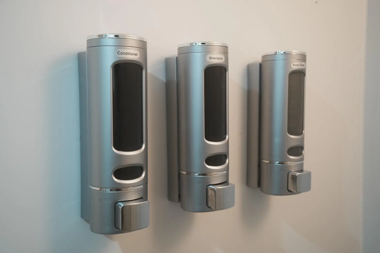 Shampoo, conditioner and body soap dispensers in shower room at Hostel JAZ